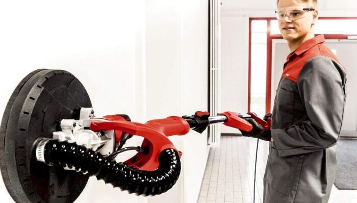 Un homme employant une ponceuse girafe Einhell